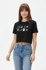 Remera cropped de algodón negra con cuello redondo y estampado frontal de símbolos en blanco.