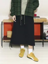 Falda cargo larga de corte recto en color negro, con cintura elástica ajustable mediante cordones y ruedo regulable con tiras laterales. Presenta un diseño funcional con bolsillos tipo cargo.