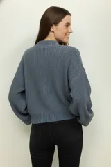 Sweater de tejido de punto grueso, color gris oscuro, con cuello redondo y mangas largas abullonadas.