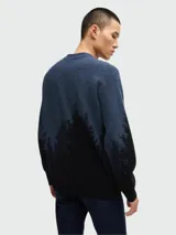 Sweater de punto con cuello redondo y diseño degradado que presenta un estampado de bosque de pinos en la parte inferior, con transición de color azul a negro.