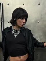 Collar de cadena de eslabones gruesos en acero quirúrgico, con múltiples dijes colgantes en forma de cruces de diversos estilos, puntas metálicas y cuentas de cristal transparente.