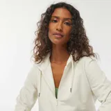 Buzo de muletón blanco off-white con capucha, cierre frontal de cremallera, bolsillos tipo canguro y cordón ajustable en la capucha.