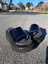 Ojota urbana de cuero con plataforma corrida marrón y faja ancha en color blanco con textura símil cocodrilo y separación para el dedo.