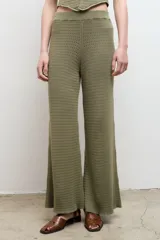 Pantalón largo color crema, de punto acanalado y corte recto.