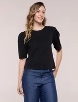 Remera de algodón negro, de silueta semi entallada, con escote redondo y mangas cortas abullonadas al codo con frunces en los hombros.