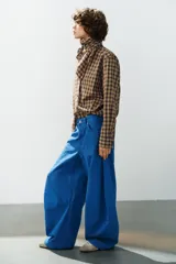 Jeans de tiro medio estilo balloon en color negro, con diseño de cinco bolsillos, trabillas para cinturón y cierre frontal con cremallera y botón metálico.