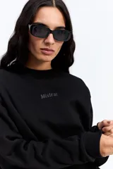 Buzo de algodón color crema, con cuello redondo, mangas largas y calce relajado. Presenta el logo de la marca bordado en el centro del pecho.