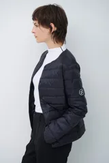 Campera acolchada tipo puffer en color beige, con diseño sin cuello y cierre frontal con botones a presión.