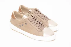 Championes de cuero legítimo color dorado con acabado metalizado, pasamontañas con cordones al tono y suela blanca con detalles de perforaciones laterales y talón contrastante.
