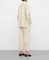 Pantalón barrel fit de cuero sintético color beige, con cintura elástica y bolsillos laterales.