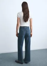 Pantalón de jean tiro alto con diseño culotte, cierre frontal de cremallera y botón, y bolsillos traseros.