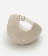 Gorra estilo dad hat de color beige, confeccionada en sarga de algodón y yute. Posee visera curva, diseño liso sin estampas y ajuste posterior con hebilla.