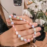 Correa para teléfono con cuentas de colores pastel y corazones sonrientes.