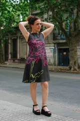 Vestido corto negro con estampado de una flor magenta y verde.