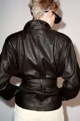 Chaqueta ZARA Woman Collection efecto piel en color marrón oscuro, de manga larga y cuello smoking. Cuenta con cinturón ajustable del mismo material para atar en la cintura y forro interior.