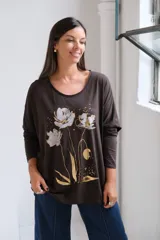 Remera de algodón color chocolate con cuello redondo, mangas largas y estampa frontal de flores en tonos plateado y dorado.