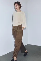 Pantalón cargo de tiro medio en color marrón, confeccionado con mezcla de lana. Presenta cintura con detalle de vuelta, pliegues frontales, bolsillos laterales y bolsillos con solapa en las piernas. Cierre frontal con cremallera, botón y ganchos metálicos.