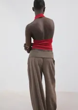 Top rojo de punto fino, con cuello halter drapeado, diseño recto y sin mangas.