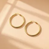 Aros en oro de 10K tipo argolla grande, de diseño clásico y acabado brillante.