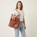 Bolso de eco cuero con textura símil gamuza en color marrón terracota, con detalles de refuerzo en eco cuero liso color tostado en las esquinas inferiores y asas. Cuenta con gran capacidad, ideal para uso diario.