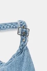 Vestido corto de denim con cuello halter, espalda descubierta y diseño de lavado combinado en tonos de azul.