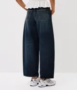 Pantalón de jean corte barrel con cintura media, trabillas para cinturón, bolsillos delanteros y traseros, cierre tradicional y detalle de recorte transversal en los laterales.