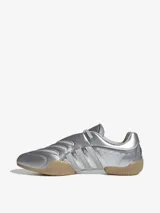 Zapatillas Adidas Taekwondo Mei Elite de diseño estilizado en color plateado metalizado, con sistema de amarre asimétrico, costuras decorativas en la punta y suela de goma color caramelo.