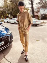 Pantalón de lino metalizado color dorado, de corte recto, con bolsillos laterales y traseros, y elástico en la cintura.