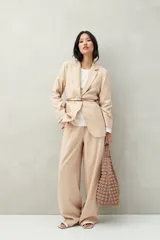 Blazer color crema a rayas verticales finas, de corte recto y solapas clásicas.