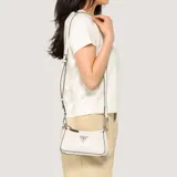 Cartera bandolera Guess modelo Holly, color blanco con relieve de logo y herrajes plateados. Cuenta con diseño de doble compartimento con cierre y correa ajustable.