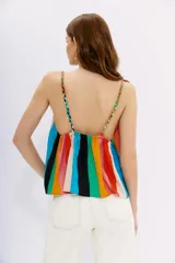 Top de calce holgado confeccionado en viscosa con estampado de rayas verticales multicolores. Presenta breteles trenzados en tonos contrastantes y elástico en la espalda para un mejor ajuste.