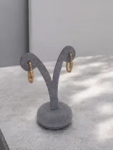 Par de caravanas tipo argolla con diseño de eslabón rectangular estilo mosquetón, en acabado dorado brillante.