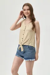 Musculosa color beige con escote en V, sin mangas, con botones y nudo en la parte inferior.