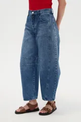 Pantalón jean de calce medio, diseño tipo barrel con pinzas y costuras decorativas, con bolsillos laterales.