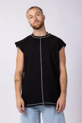 Musculosa oversize de algodón estilo sudadera, color crudo, con costuras visibles en contraste en color negro que recorren el centro verticalmente y enmarcan el cuello y el ruedo.