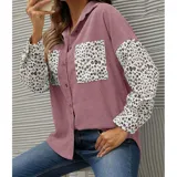 Sobre camisa de pana blanca con detalles en animal print en los bolsillos frontales y en las mangas. Presenta cuello inglés, cierre frontal con botones y corte holgado.