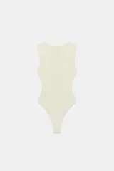 Body entallado color crema con escote en pico pronunciado, sin mangas y cierre de botones a presión en la parte inferior.