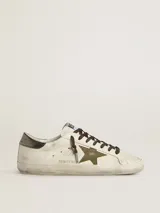 Zapatillas Golden Goose modelo Super-Star, de cuero color blanco envejecido con estrella de glitter verde y detalles en cuero color negro en el talón. Cordones marrones y suela de goma.