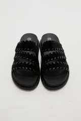 Sandalias planas color negro con tres tiras anchas adornadas con costuras cruzadas en el borde.