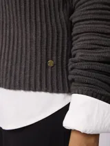 Sweater de tejido acanalado con cuello redondo y manga larga. Presenta un corte relajado y textura estructurada.
