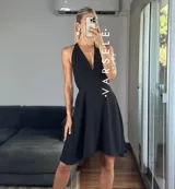 Vestido corto rojo con escote halter, espalda descubierta y falda acampanada.