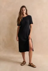 Vestido midi negro de manga corta, confeccionado en tejido de punto acanalado, con cuello redondo y corte recto.