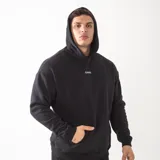 Canguro oversize de felpa premium en color negro, con capucha y bordado de alta calidad en la espalda con la frase 'RESILIENCE BUILT IN SILENCE'.