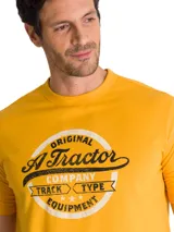 Remera Caterpillar de color amarillo, con cuello redondo y mangas cortas. Presenta un estampado gráfico circular en el pecho con diseño vintage inspirado en tractores.