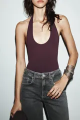 Body de cuello halter confeccionado en tejido rib, con diseño de espalda descubierta y cierre inferior.