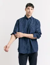 Camisa azul oscuro con estampado de motas blancas, de manga larga y corte clásico.