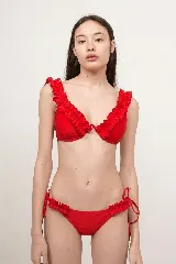 Conjunto de bikini rojo con volados decorativos en los breteles del corpiño y en los laterales de la bombacha, que cuenta con tiras ajustables.