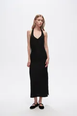Vestido midi negro de corte al cuerpo, con escote halter profundo y detalle de frunce en el centro del busto.