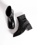 Botín de cuero con estampado de piel de serpiente en tonos blanco y negro, con puntera cuadrada y tacón bloque bajo.