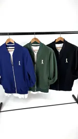 Campera bomber verde con textura tipo waffle, cierre frontal y logo pequeño bordado en blanco en el pecho.